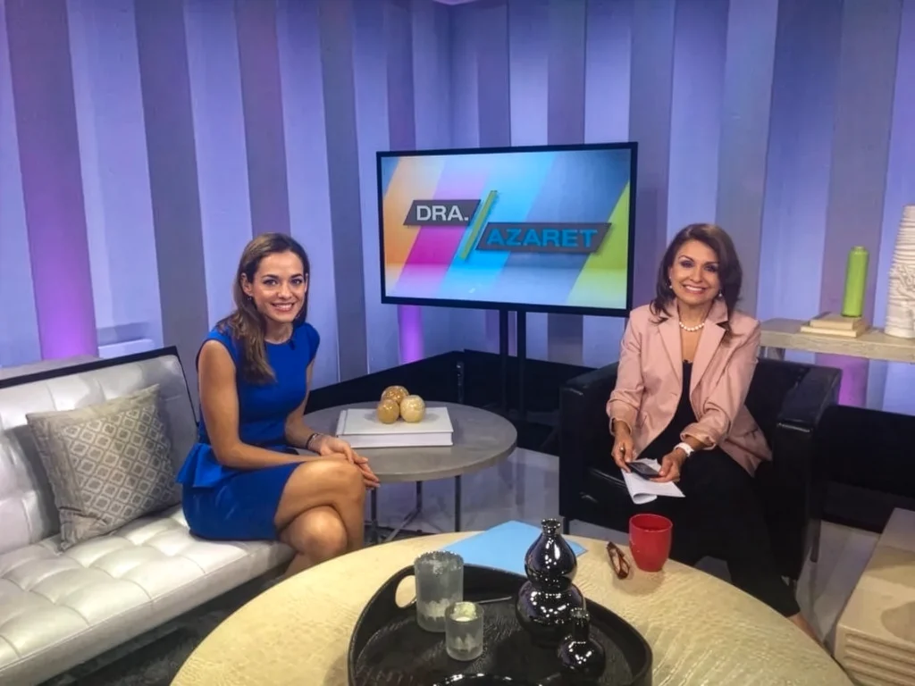 Dr Diana on a tv set with Dr Azaret. Diana sits on a couch to the left and Dr Azare to the right.