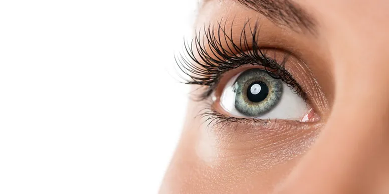 Extreme close up of a woman's green eye looking up