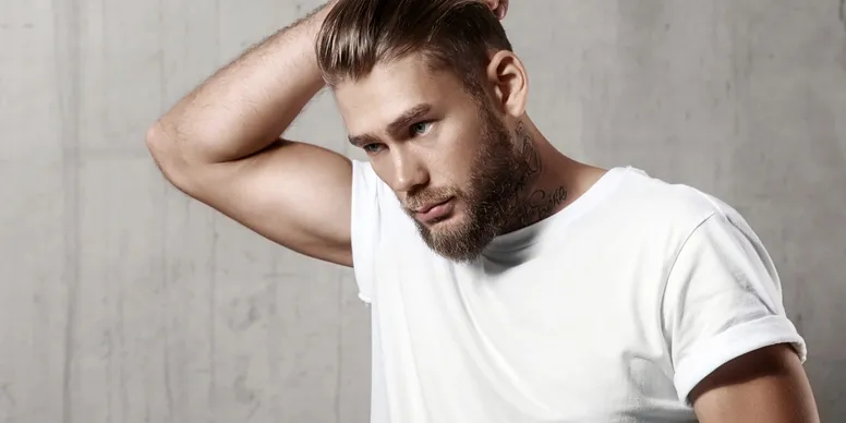 Man looking down with his hand up holding the back of his head