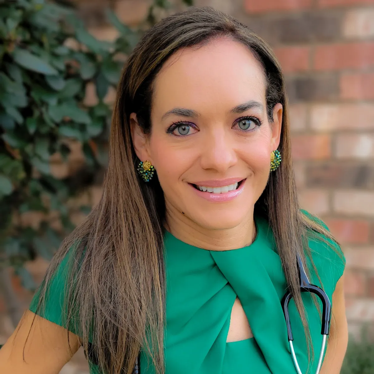 Dr Diana Londono portrait in a green dress with stethoscope around neck
