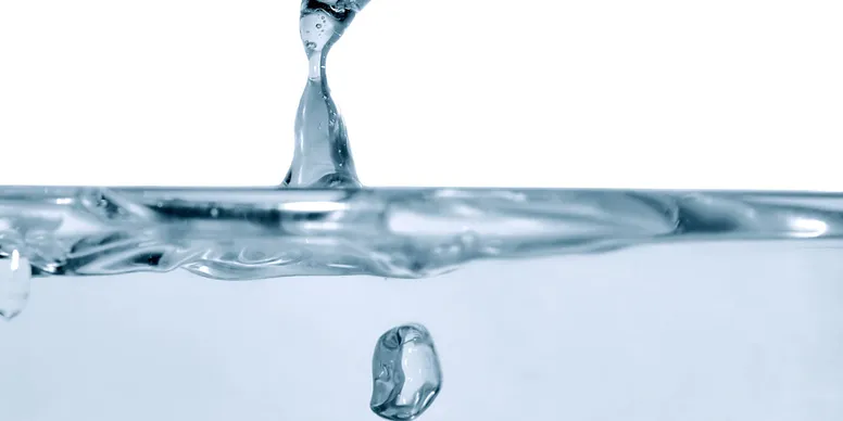 A close up of liquid with a drop splashing