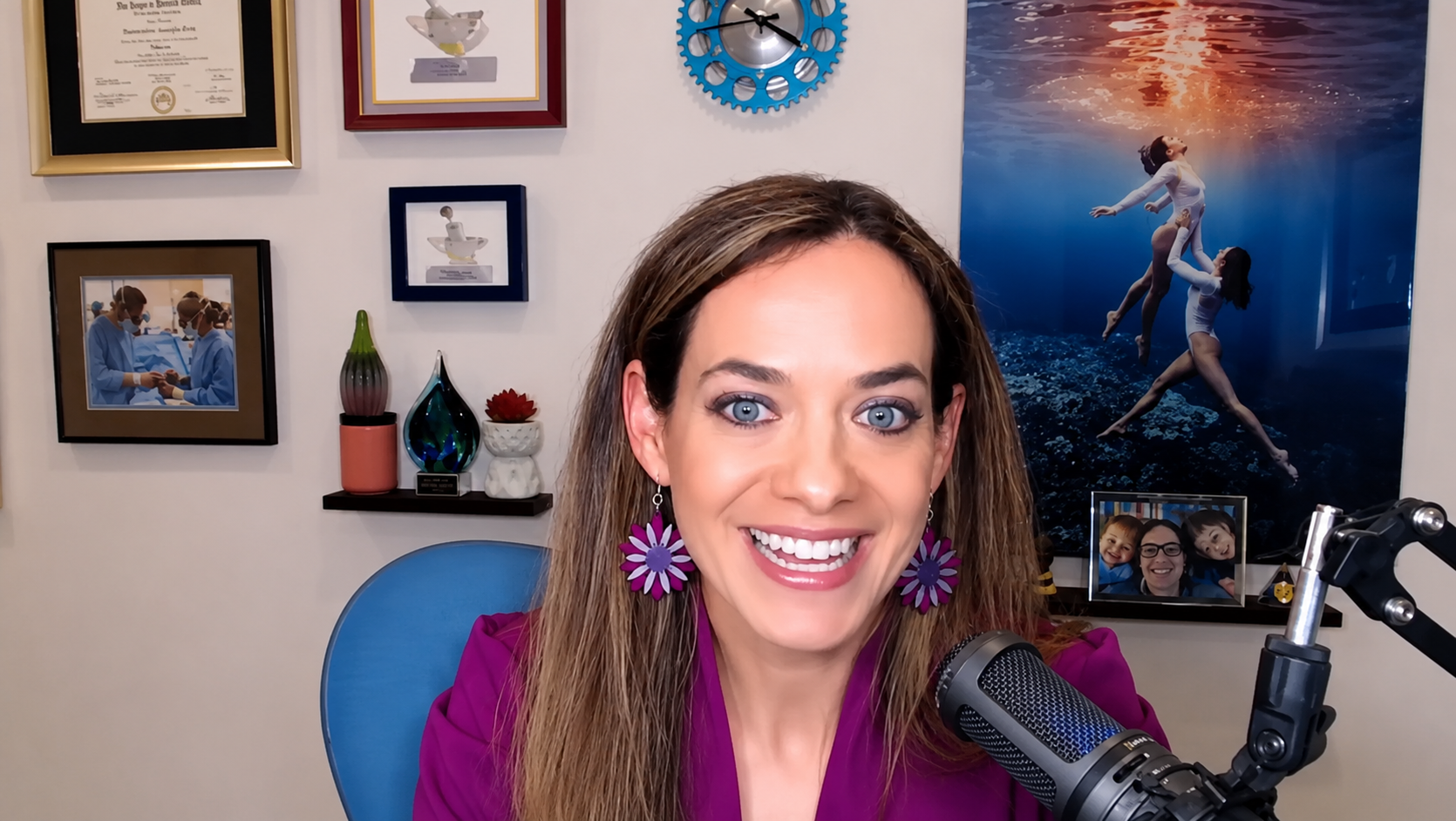 Dr Londono smiling during a podcast interview in her home studio with pictures and degrees hanging on the wall behind her